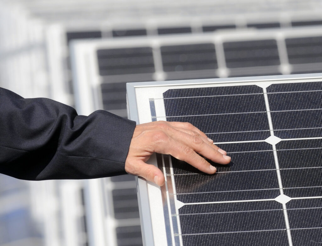 Roka na sončnih celicah sončne elektrarne, ki je postavljena na strehi stavbe Energetika Ljubljana